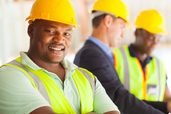 smiling african industrial engineer with colleagues